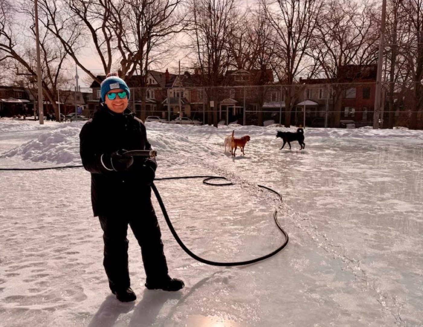 Marco Martins flooding the natural environment ice rink with a hose in a Ward 9 park